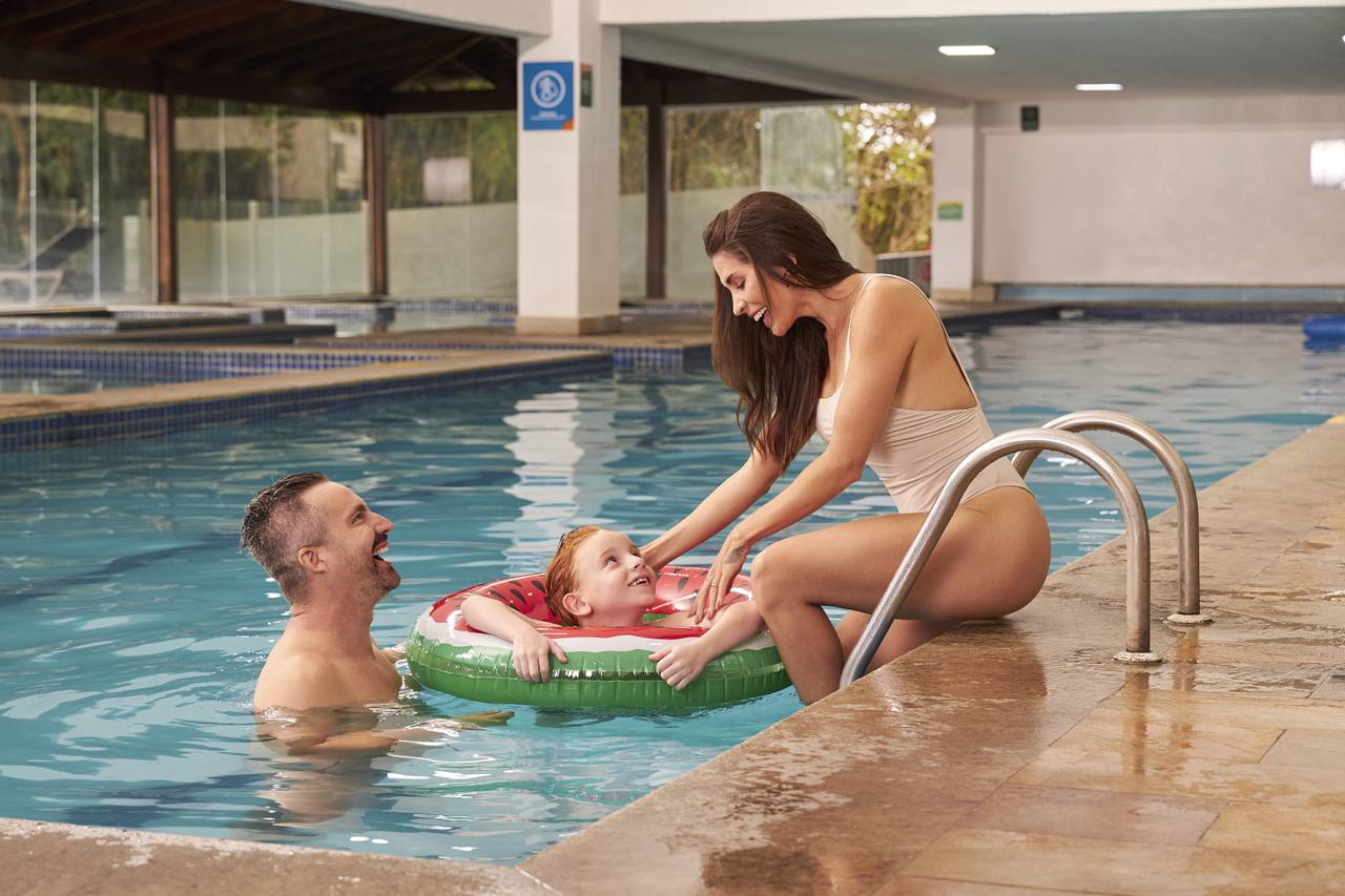 banner casal com criança na piscina