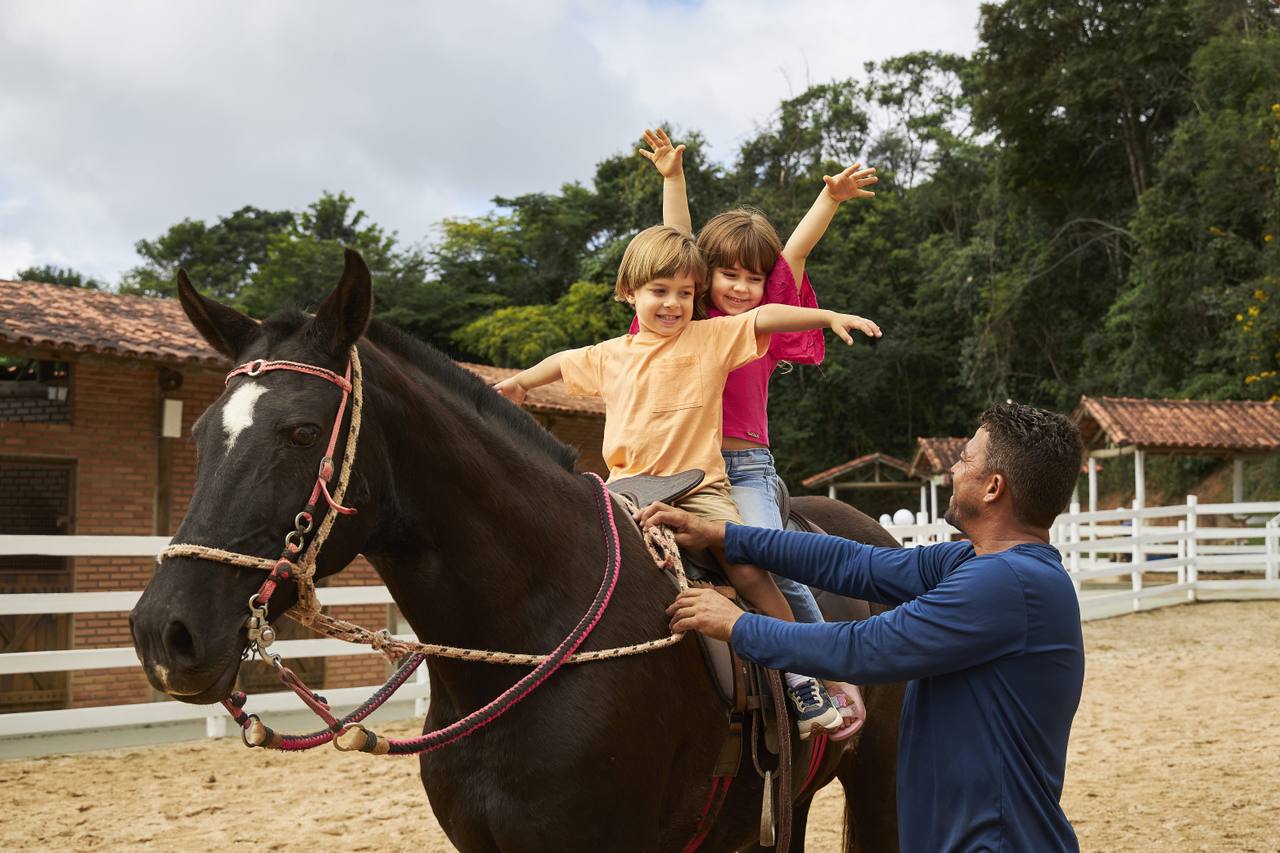 crianças se preparando para andar a cavalo